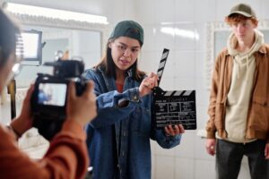 Filmmaker Holding Clapboard with Crew Member Observing